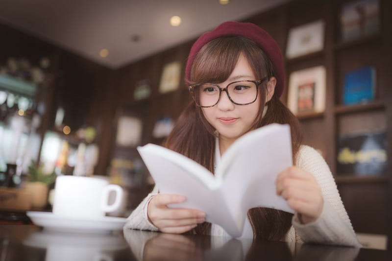 PAKUTASO　カフェで調べ物をするメガネをかけた美少女写真素材